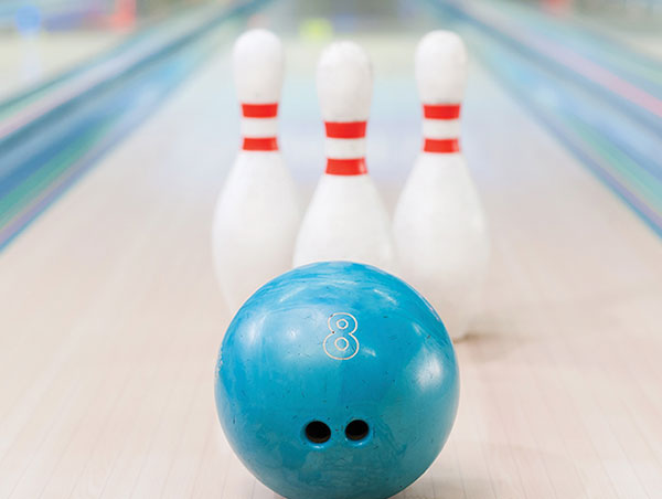 Bowling ball in front of three pins